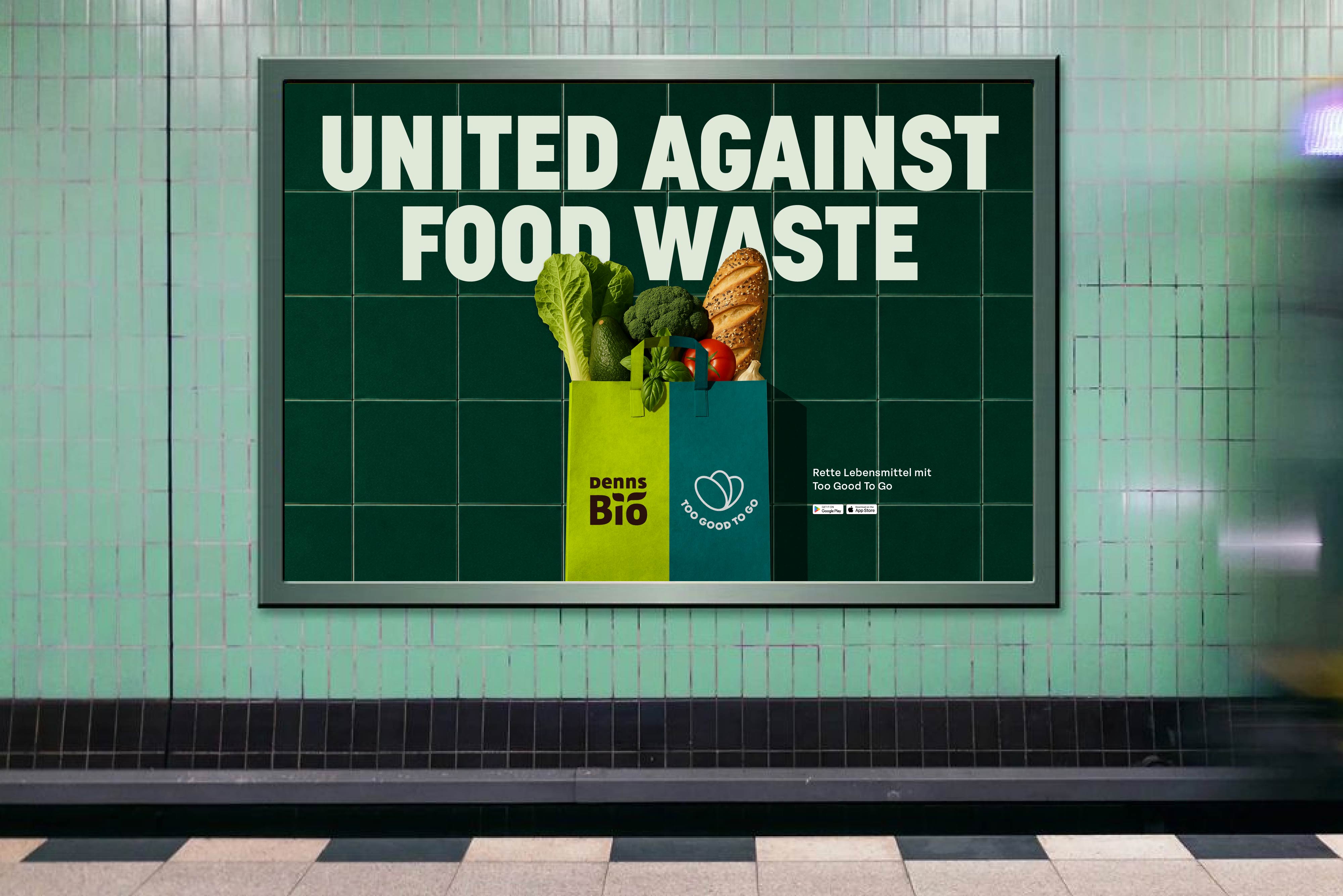 'United Against Food Waste' poster with Denns Bio on a subway tile wall